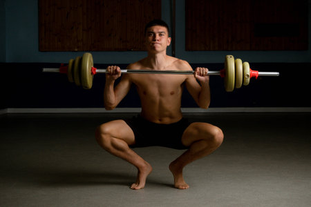 Shirtless 19 year old teenage boy lifting a barbellの写真素材
