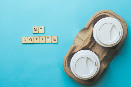 A cardboard with 2 paper coffee cups and lids with a sign reading My Coffeeの写真素材