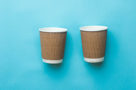 Two empty paper coffee cups on a blue backgroundの写真素材