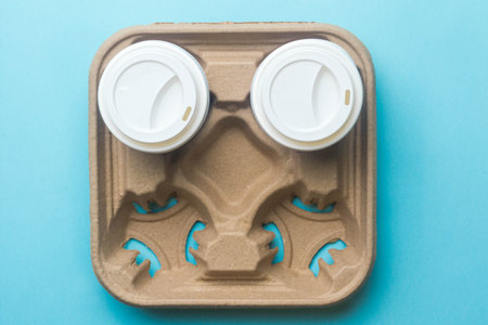 A cardboard tray for carrying paper coffee cups with two cups and lidsの写真素材