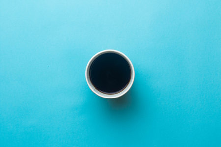 An open cup of black coffee on a blue black groundの写真素材