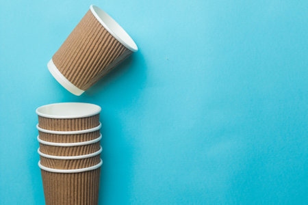 A Single empty coffee cup above  a stack of cups on a blue backgroundの写真素材