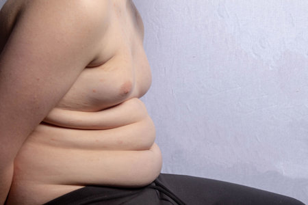 An overweight shirtless caucasian teenage boy sitting downの写真素材