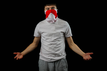 Teenage boy wearing an England flag mask against a black backgroundの写真素材