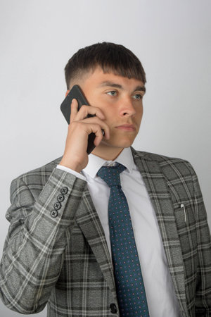Young entrepreneur wearing a suit and tie making a phone callの写真素材
