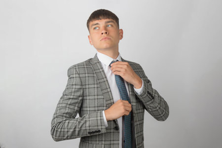 Young entrepreneur wearing a suit and tie adjusting his tieの写真素材