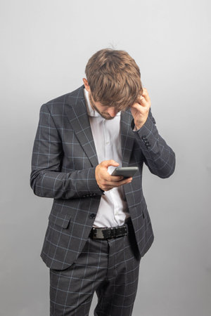 Portrait of a young businessman or entrepreneur in a jacked and an open neck shirt
holding a mobile phoneの写真素材