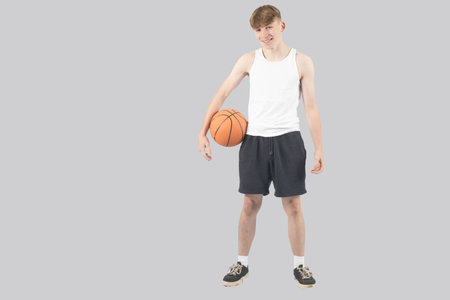 Caucasian teenage boy holding a basketballの写真素材