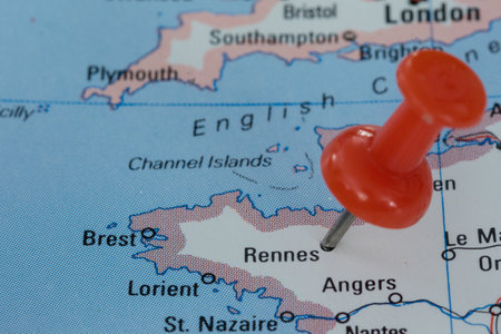 A red pin stuck into a map of Western Europe, pinpointing the location of Rennesの写真素材