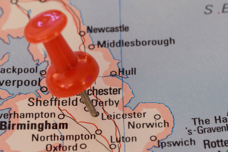 A red pin stuck into a map of Western Europe, pinpointing the location of Leicesterの写真素材