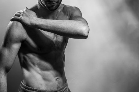 A young male body with well-defined abs and chest. Model with shirtless torso. Concept of body care, male health, fitness, youth, masculinity, health, weightloss, bodybuildingの写真素材