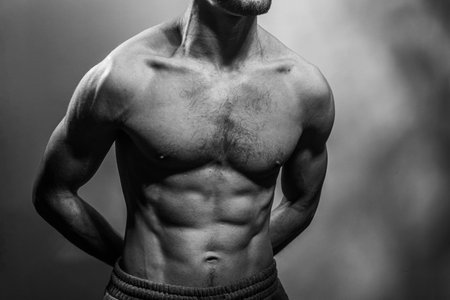 A young male body with well-defined abs and chest. Model with shirtless torso. Concept of body care,...