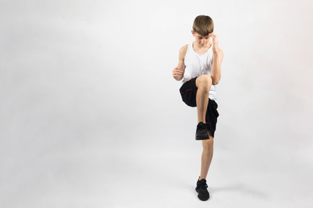 Fifteen year old teenage boy doing knees to elbows, studio shot against a white backgroundの写真素材
