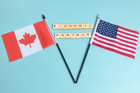 The Flags of The United States and Canada trade war concept, with tiles reading Economic Partnerの写真素材