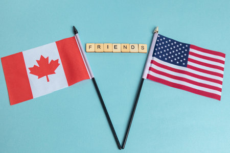 The Flags of The United States and Canada trade war concept, with tiles reading Friendsの写真素材