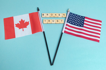 The Flags of The United States and Canada trade war concept, with tiles reading Broken Trustの写真素材
