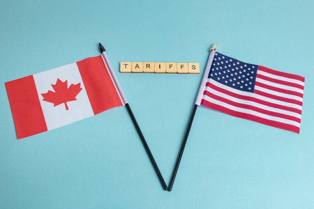 The Flags of The United States and Canada trade war concept, with tiles reading Tariffsの写真素材