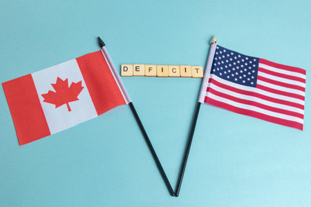 The Flags of The United States and Canada trade war concept, with tiles reading Deficitの写真素材