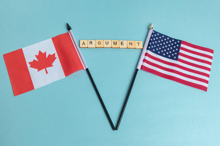 The Flags of The United States and Canada trade war concept, with tiles reading Argumentの写真素材
