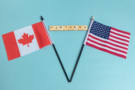 The Flags of The United States and Canada trade war concept, with tiles reading Partnersの写真素材