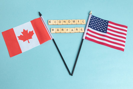 The Flags of The United States and Canada trade war concept, with tiles reading Economic Warefareの写真素材
