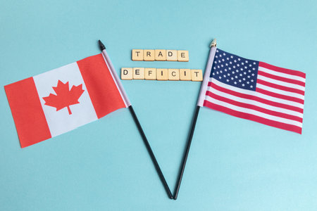 The Flags of The United States and Canada trade war concept, with tiles reading Trade Deficitの写真素材