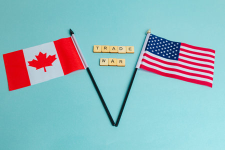 The Flags of The United States and Canada trade war concept, with tiles reading Trade Warの写真素材