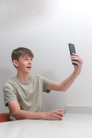 Teenage boy taking a selfie with a mobile phoneの写真素材