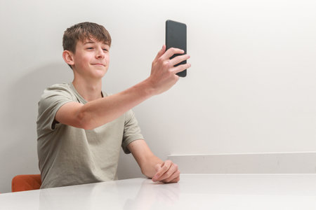 Teenage boy taking a selfie with a mobile phone