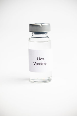 Vaccine concept, an Isolated medical vial with a label reading Live Vaccine on a plain white...
