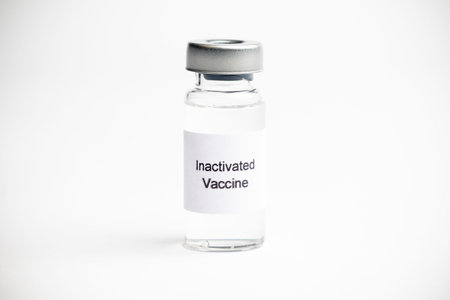 Vaccine concept, a medical vial with a label reading Inactivated Vaccine on a plain white...