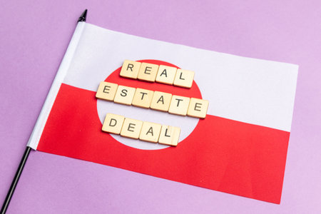 The Flag of Greenland Against A Purple Background With The Sign Reading Real Estate Dealの写真素材
