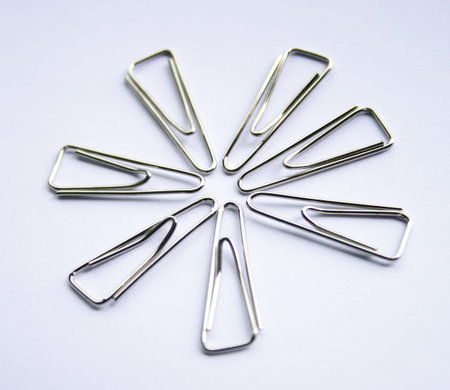 Metal Paper Clips On White Background form up a pattern.