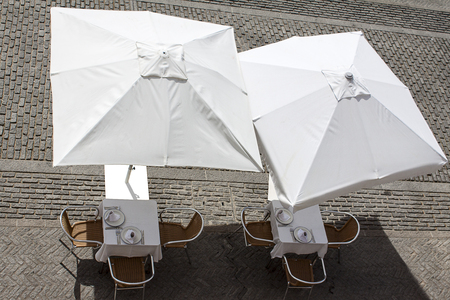 summer terrace with tables and white umbrellasの写真素材