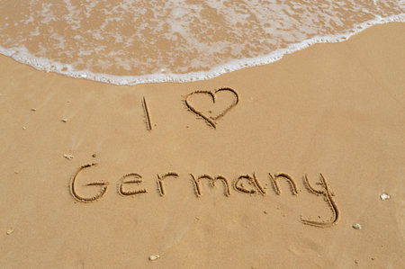 The text 'I love Germany' written in the sand at a tropical beachの写真素材