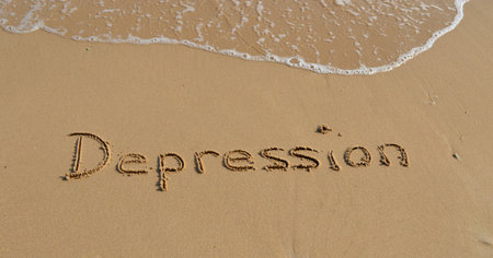 The word 'Depression' written in the sand at the beachの写真素材