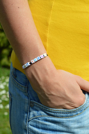 Woman wearing a bracelet with the message "eat vegan"の写真素材