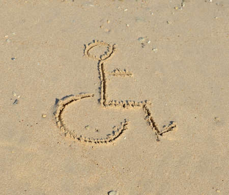 A disabled symbol is drawn in the sand at the beachの写真素材