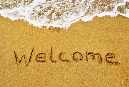 The word Welcome written in the sand at the beachの写真素材