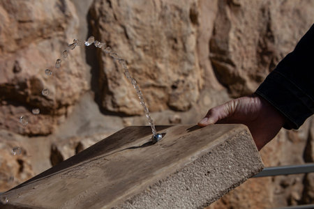 drinking water from a fountain in the heat among the stones of a red-hot city