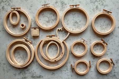Assorted wooden embroidery hoops on gray textured background. That the image is generated using AI.の素材