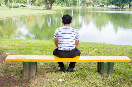 Man sitting on a bench in a park in a quiet view.の写真素材