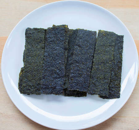 Crispy seaweed lying on white dishの写真素材