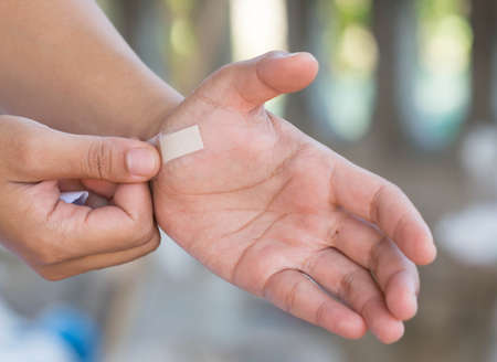 Stick a plaster on the wound in the hand.の写真素材