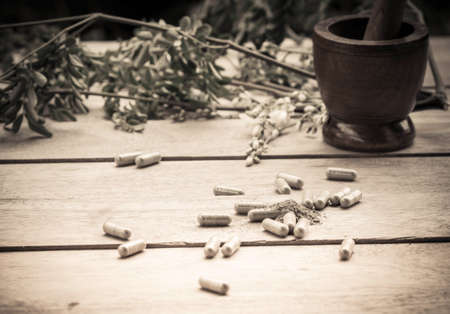 Herbal medicine capsule on a wooden floor.の写真素材
