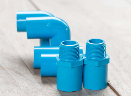 Blue pvc plumbing fittings on the wooden floor.の写真素材
