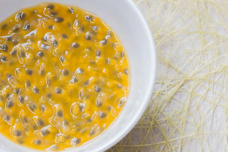 Passion fruit pulp in a cup on the ground.の写真素材