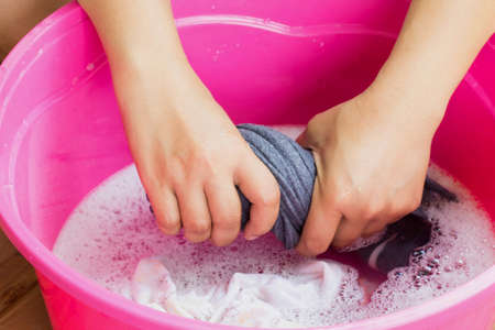 Hand washing clothes in the basin blue.の写真素材