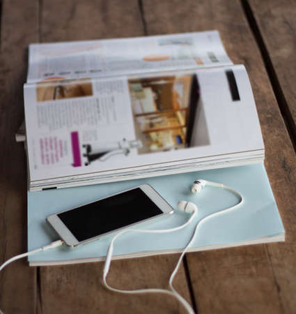 Magazine with smart phone on the wooden floor.の写真素材