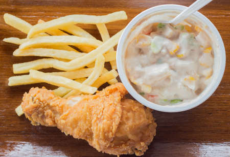 Fried chicken and salad with French Fries on wooden plateの写真素材